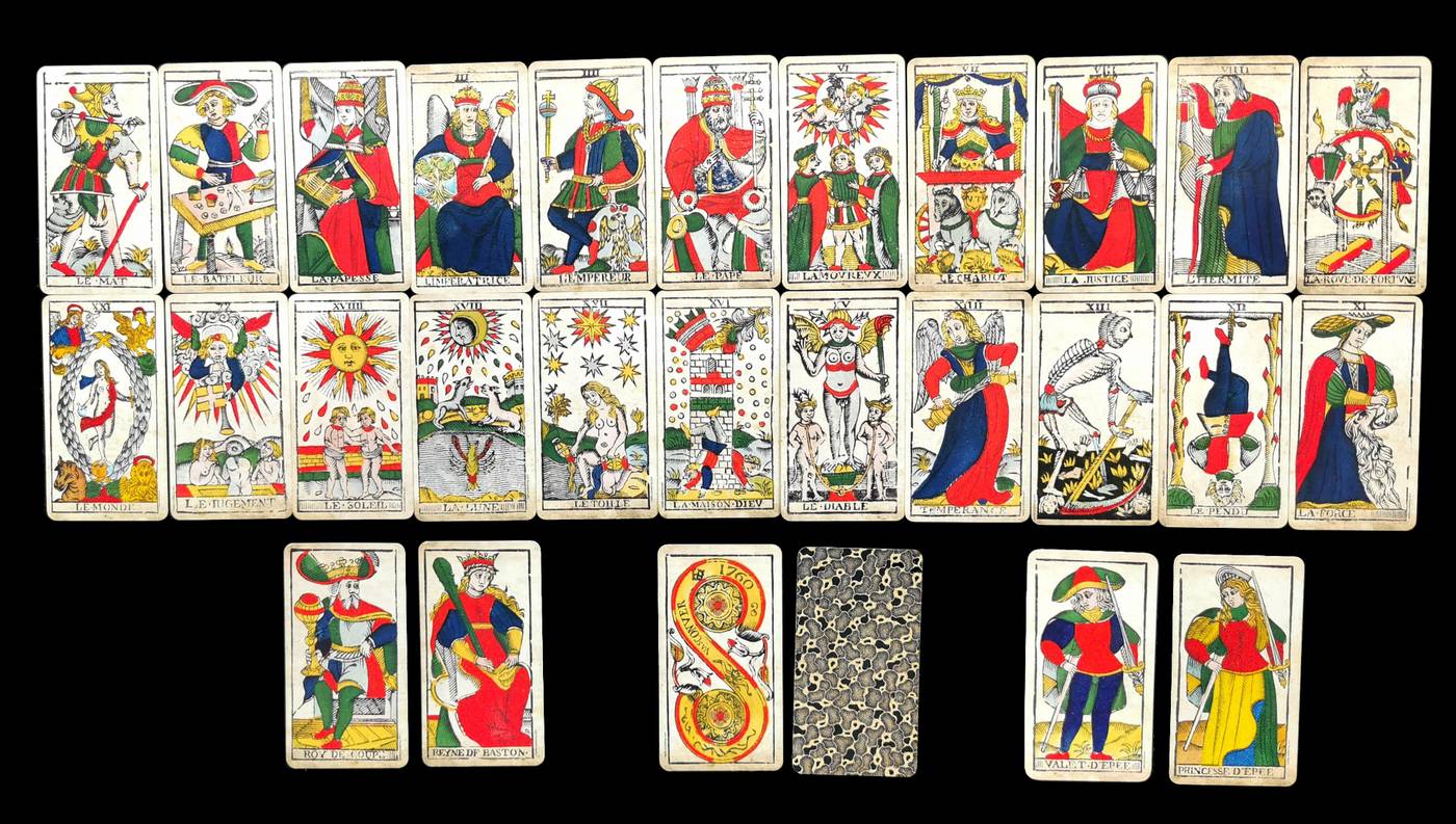 Die 22 Großen Arkana des Tarot de Marseille in leuchtenden Farben auf schwarzem Grund ausgelegt, darunter einige Beispielkarten